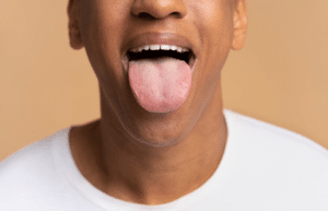 imagem frontal de rosto masculino mostrando a lingua