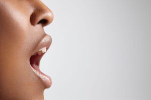 perfil de mulher com a boca aberta falando