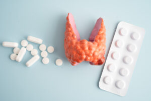 representação da tireoide e medicamentos para problemas na tireoide sobre fundo azul