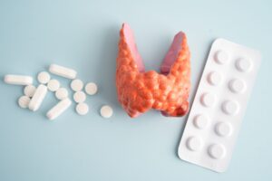 representação da tireoide e medicamentos para problemas na tireoide sobre fundo azul